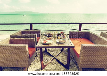 Breakfast outside at the hotel by the sea. Modern outdoor ocean view restaurant. Toned image