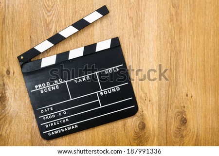 Movie production clapper board against wooden background with copy space