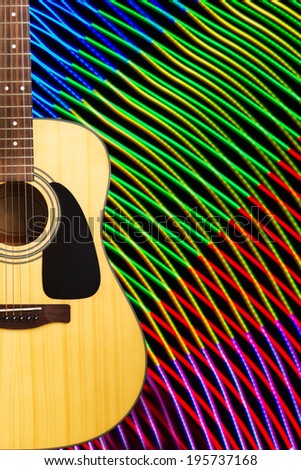 Acoustic guitar against abstract background made of light painting or freezelight