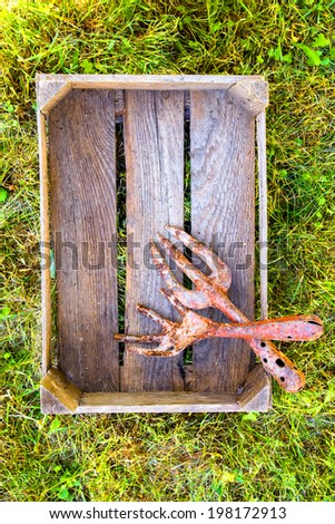 Vintage gardening tools in wooden container outdoors