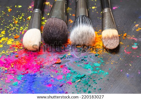 Makeup concept. Makeup brushes on a background with colorful powder