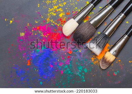 Makeup brushes on a background with colorful powder. Makeup concept