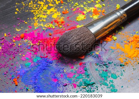 Makeup brush on a background with colorful powder. Makeup concept