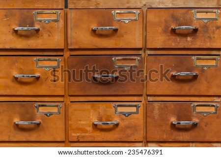 Close-up of drawers with blank tags in vintage furniture module