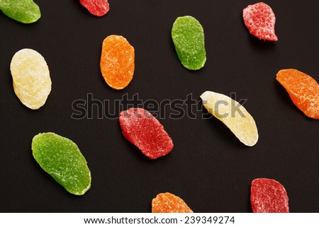 Colorful sweet candied fruit over a black background. Candied dried fruit