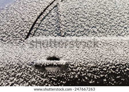 Close-up of a car under the snow. Frozen door of a car