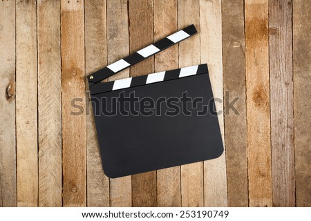 Movie clapper board on a vintage wooden background