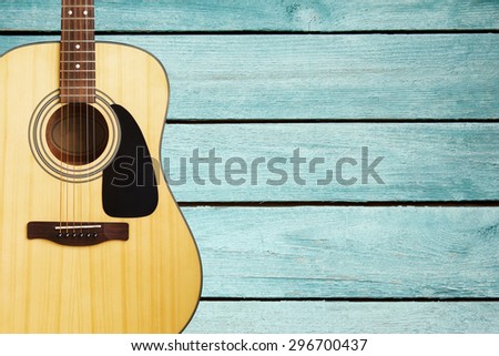 Acoustic guitar on turquoise vintage wooden wall