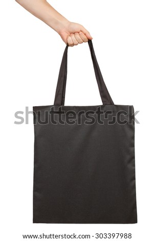 Hand holding fabric tote bag isolated on white background