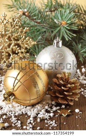 Golden Christmas composition with pine cone on the snow.
