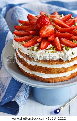Sweet homemade cake with strawberry and whipped cream on a cake stand Sweet homemade cake with strawberry and whipped cream on a cake stand