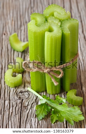 Bunch of fresh celery stalks on a wooden background.