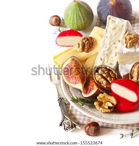 Assortment of delicious cheese and fruits on a plate.