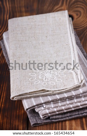 Pile of linen table napkins on a wooden background.
