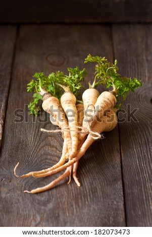 Bunch of fresh parsley roots on a wooden board.