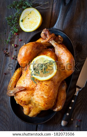 Whole roasted chicken with lemon and thyme on a pan Rustic style Whole roasted chicken with lemon and thyme on a pan Rustic style