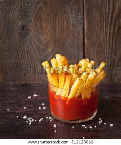 Fried potatoes with tomato sauce served in glass.