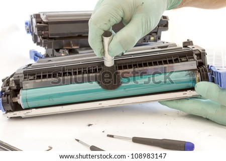 hands cleaning toner cartridge with brush the dust. worker Laser printer on a workbench. Printer workshop