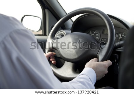 Man with the hands on wheel driving car close up