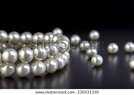 white pearls necklace on black background