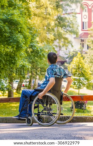 Young man in wheelchair in city park