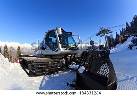 Snow-grooming machine on snow hill ready for skiing slope preparations in Russian Krasnaya Polyana