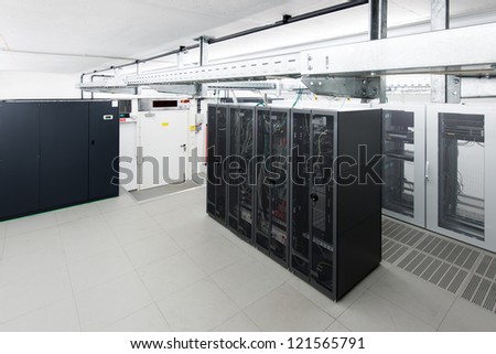 small air conditioned server room with black racks and climate control unit
