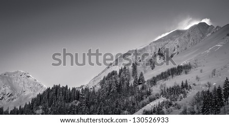 snowy mountains in austria tyrol with powder blowing over crest