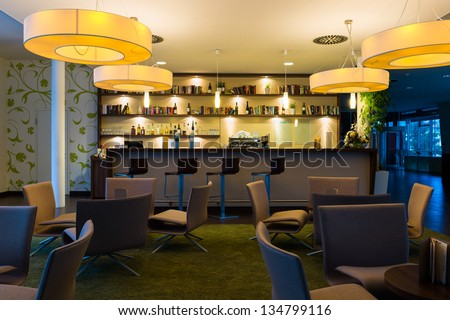 nice hotel lounge bar with bottle shelfs and seats, tables, lights