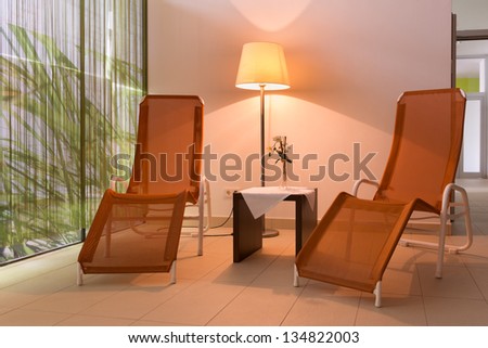 two sunloungers with lamp and table in hotel wellness area