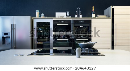 several electronic kitchen equipment with stove and timber front