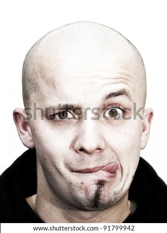  bald head teenager makes grimace with tongue outside and beard at his