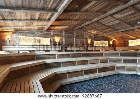large sized  sauna made with very old wood and historical ligthning images with frames at the wall
