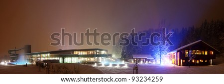 illuminated building of a swimming pool, water slide and sauna chalets and lighted tree
