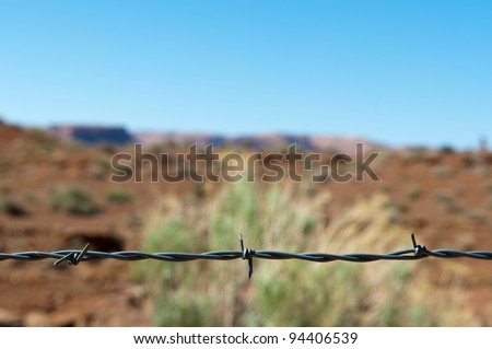 barbed wire fence made of steel in front of desert and blue sky in the USA