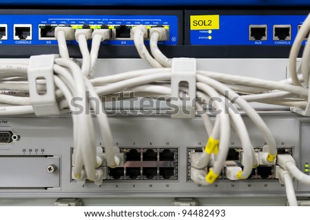 IT environment with switch and firewalls connected with grey patch ethernet cables