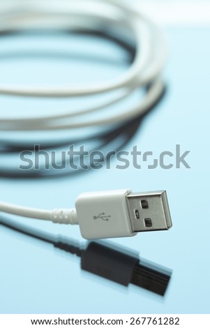 Cellphone usb cable charging cord on a blue reflective surface