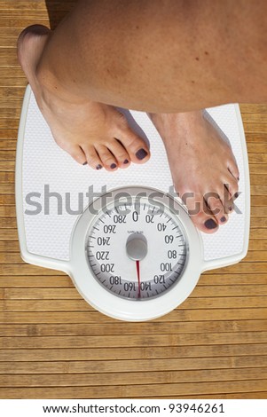 Woman Dieting, close up of woman\'s bare feet standing on a weight scale