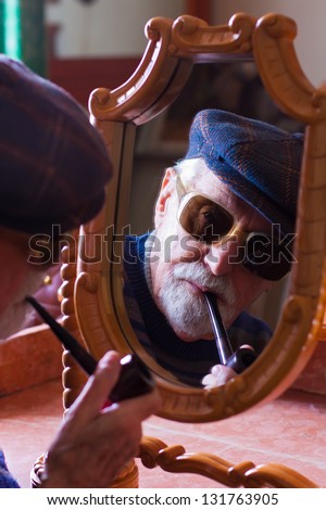 Elderly man looking at himself in the mirror.