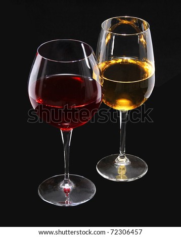 Vine glasses with red and white vine photographed over black background.
