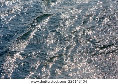 A close up of wavy sea texture with sparkling reflection of the sun