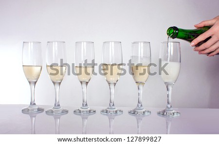 six crystal glasses of wine standing in a row
