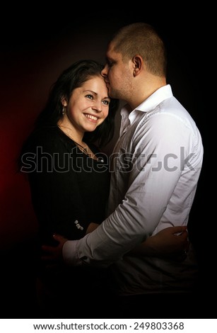 studio portrait of a young couple, man and woman embrace and kiss, love, Valentine\'s Day