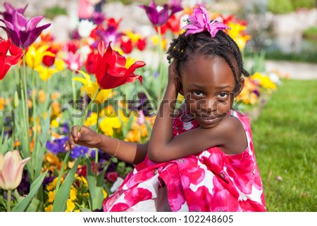 Portrait of a cute little african american girl playing in the garden