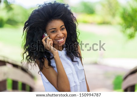 Smiling teenage black girl using a mobile phone  - African people