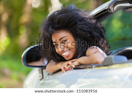 Young black teenage driver seated in her new convertible car - African people