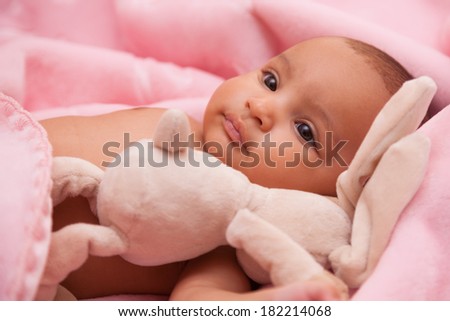 Adorable little african american baby girl playing with a plush - Black people