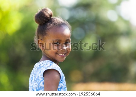 Outdoor close up portrait of a cute young black girl smiling - African people