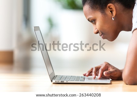 African American woman using a laptop in her living room - Black people