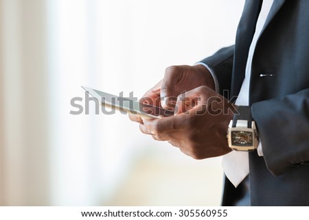 African american business man using a tactile tablet over white background - Black people